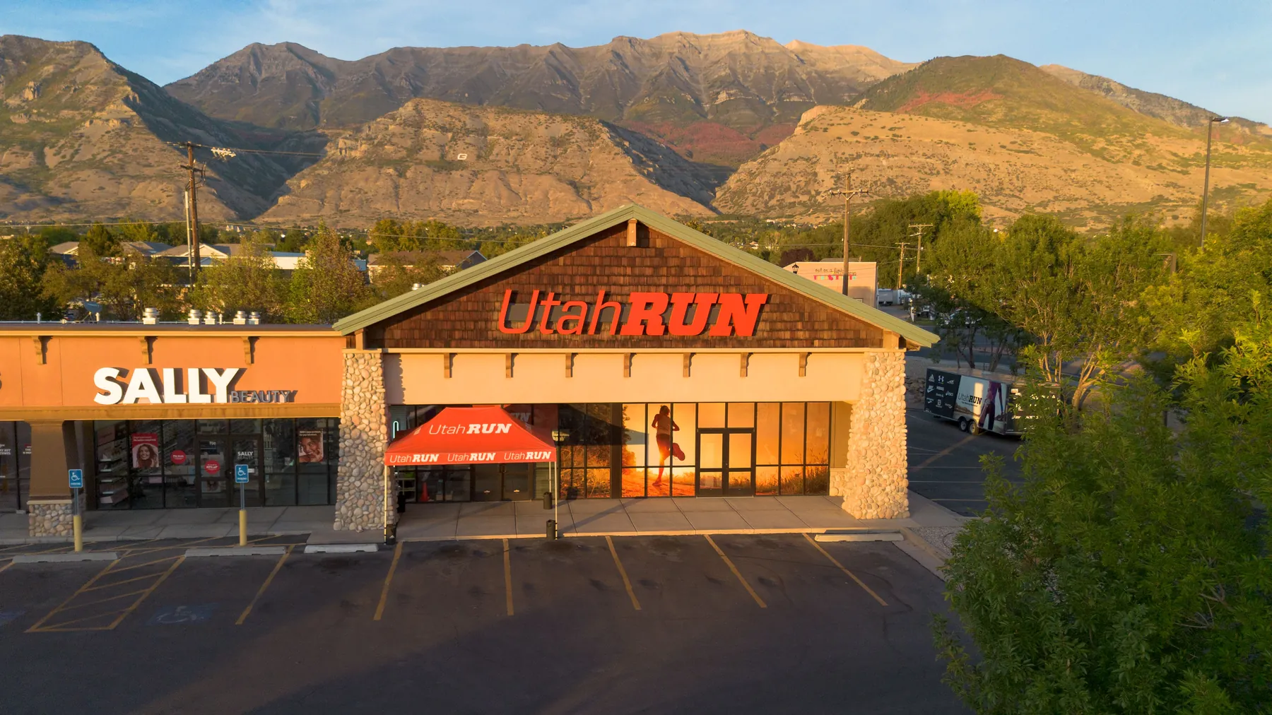 Aerial view of the UtahRUN storefront in Lindon with the Wasatch range behind at sunset