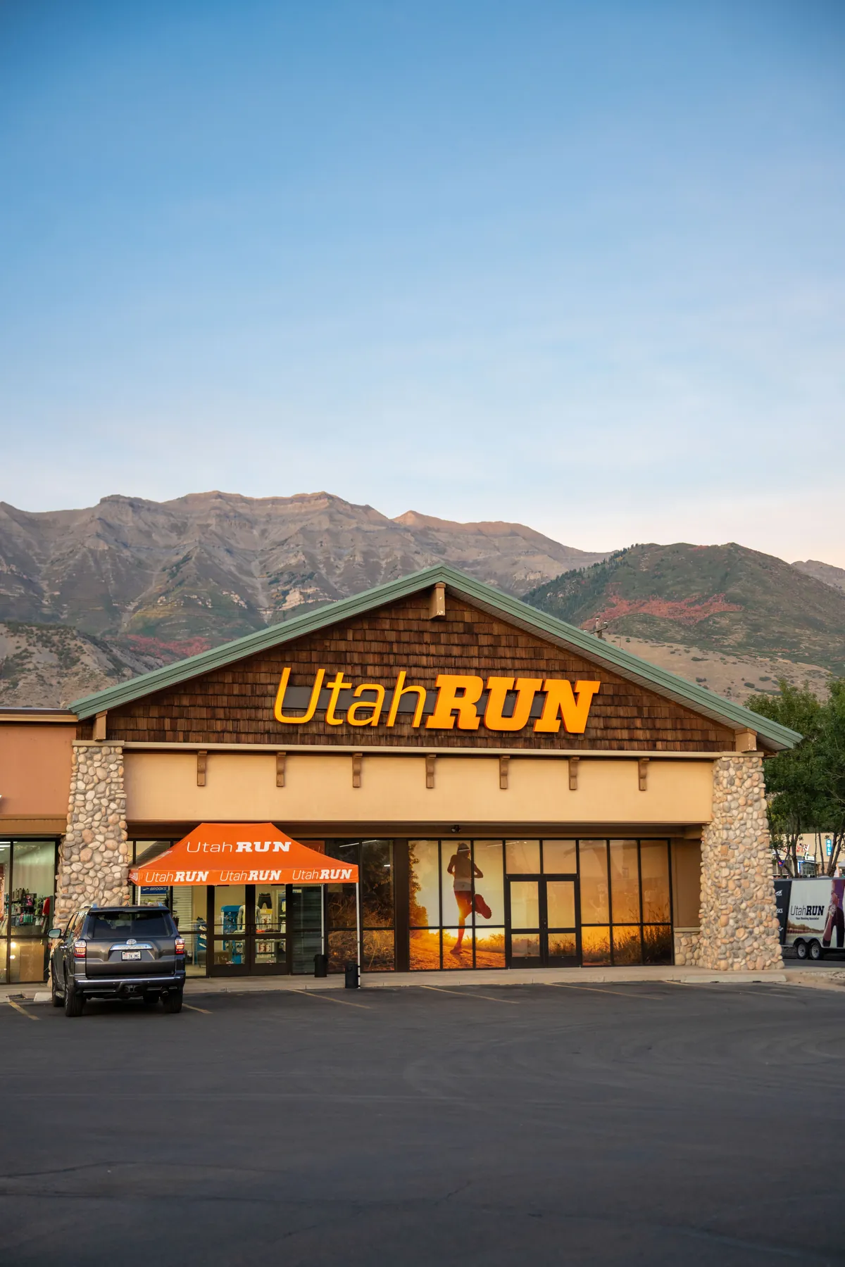 The UtahRUN storefront on State Street in Lindon at golden hour, the Wasatch mountains behind
